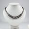 Black and white Kumihimo necklace on white bust, spiral beaded design using traditional 7-warp Japanese Kumihimo braiding